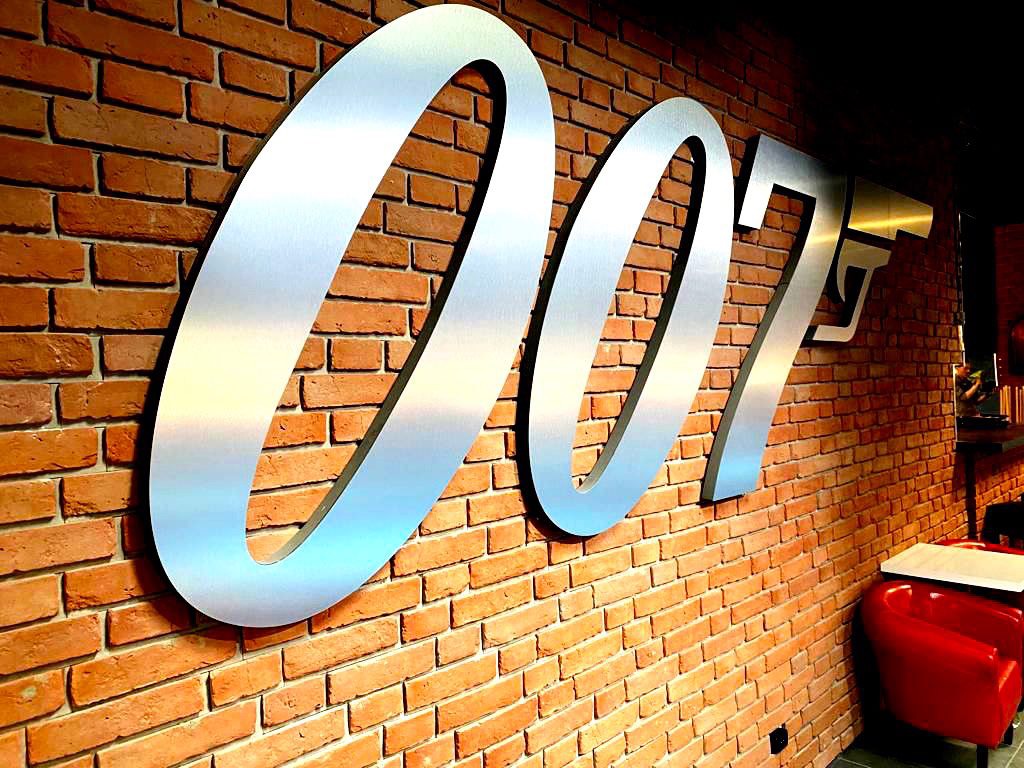 Metalowy znak 007 na ceglanej ścianie w Q Club