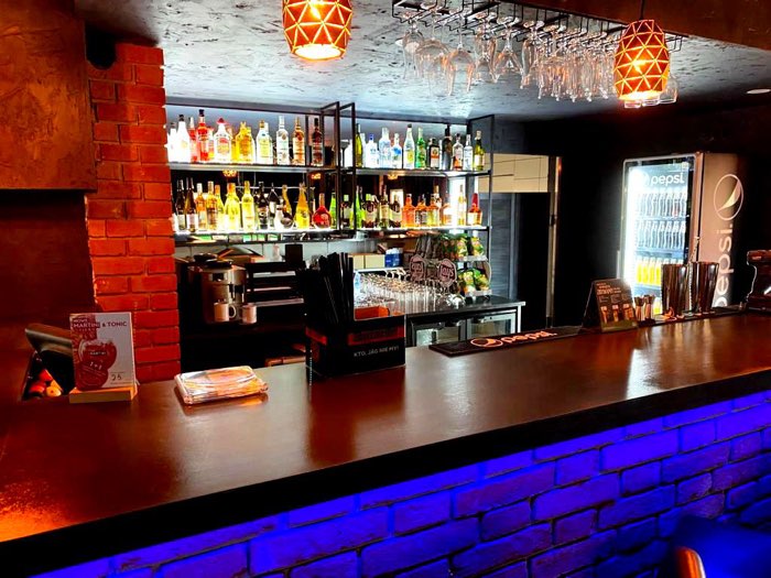 Bar z ceglaną ladą i podwieszanymi lampami