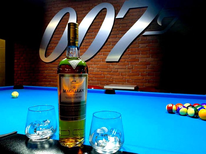 Butelka whisky i szklanki na niebieskim suknie stołu