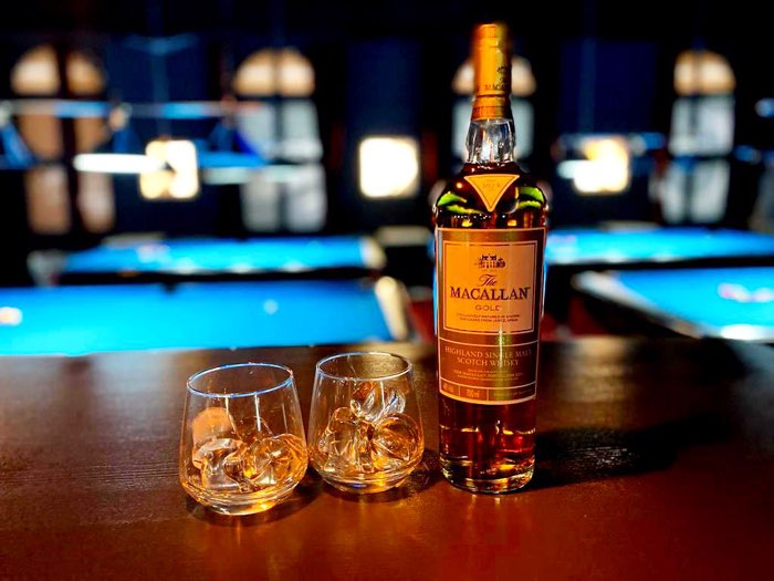 Whisky i szklanki na tle stołów bilardowych